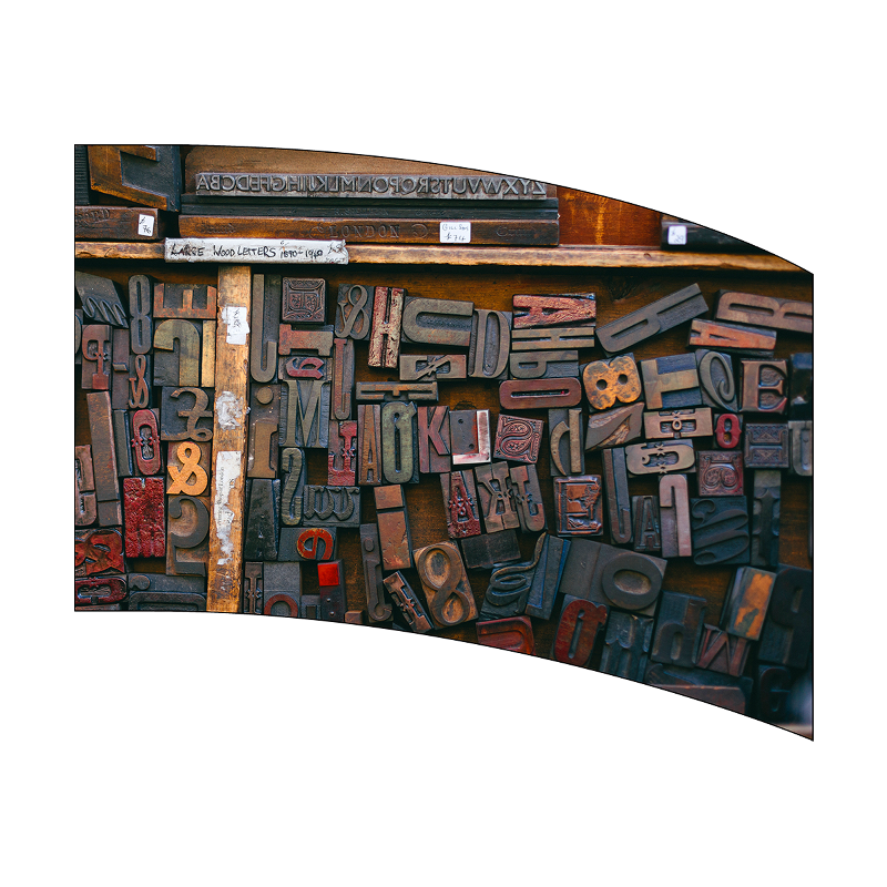 Collection of wooden letterpress printing blocks on a white background