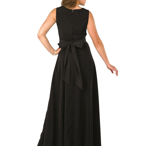 Back view of Peyton scoop neck sleeveless black dress showcasing a full-length flowing skirt, sleeveless cut, and elegant waist tie detail, designed for formal occasions, stage performances, and choir or evening wear.