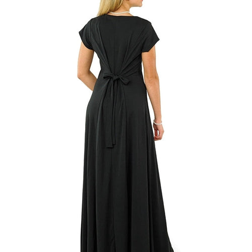 Back view of the Abigail scoop neckline short sleeve dress in classic black, showcasing a softly draped silhouette with an adjustable tie-back detail and flowing floor-length skirt, modeled against a white background; designed for formal occasions, choir performances, concerts, and elegant stage wear.