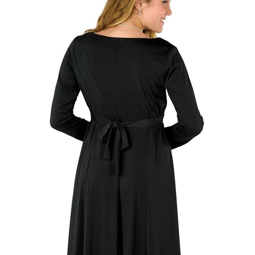 Back view of the Caroline Sweetheart Neck long sleeve black dress featuring a tied waist sash and flowing floor-length skirt, shown on a model wearing an elegant formal performance dress ideal for choir, recital, or special occasion wear.