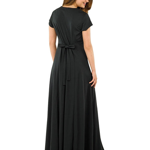 Back view of the Melissa heart-shaped neckline cap sleeve dress in black, featuring a waist-defining tie detail and flowing floor-length skirt, modeled on a woman in elegant formal attire ideal for choir performances, concerts, and special events.