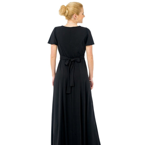 Back view of the Christina Flutter Sleeve Scoop Neckline Dress featuring a flowing black full-length silhouette with flutter sleeves, tie-back waist detail, and elegant drape, designed for choir performances, recitals, concerts, and formal stage wear.