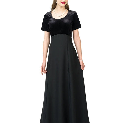 Julia velvet scoop neck short sleeve dress shown in black, featuring a fitted velvet bodice and flowing full-length skirt, worn by a model for formal choir performances, concert attire, and elegant stage wear.