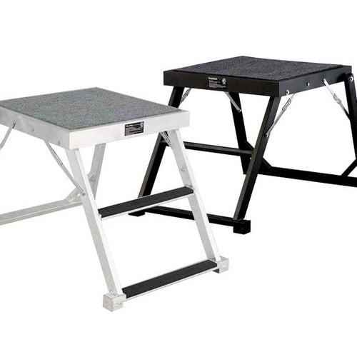 DSI 2-foot podium shown in silver and black finishes, featuring compact aluminum construction, non-slip standing platform, sturdy folding frame, and low-profile design for conductors, instructors, and rehearsal use.